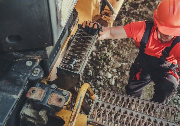 Mine Truck Driver Heavy Duty Machinery Operator Going Up on Metal Truck Ladder. Mine Truck Driving.