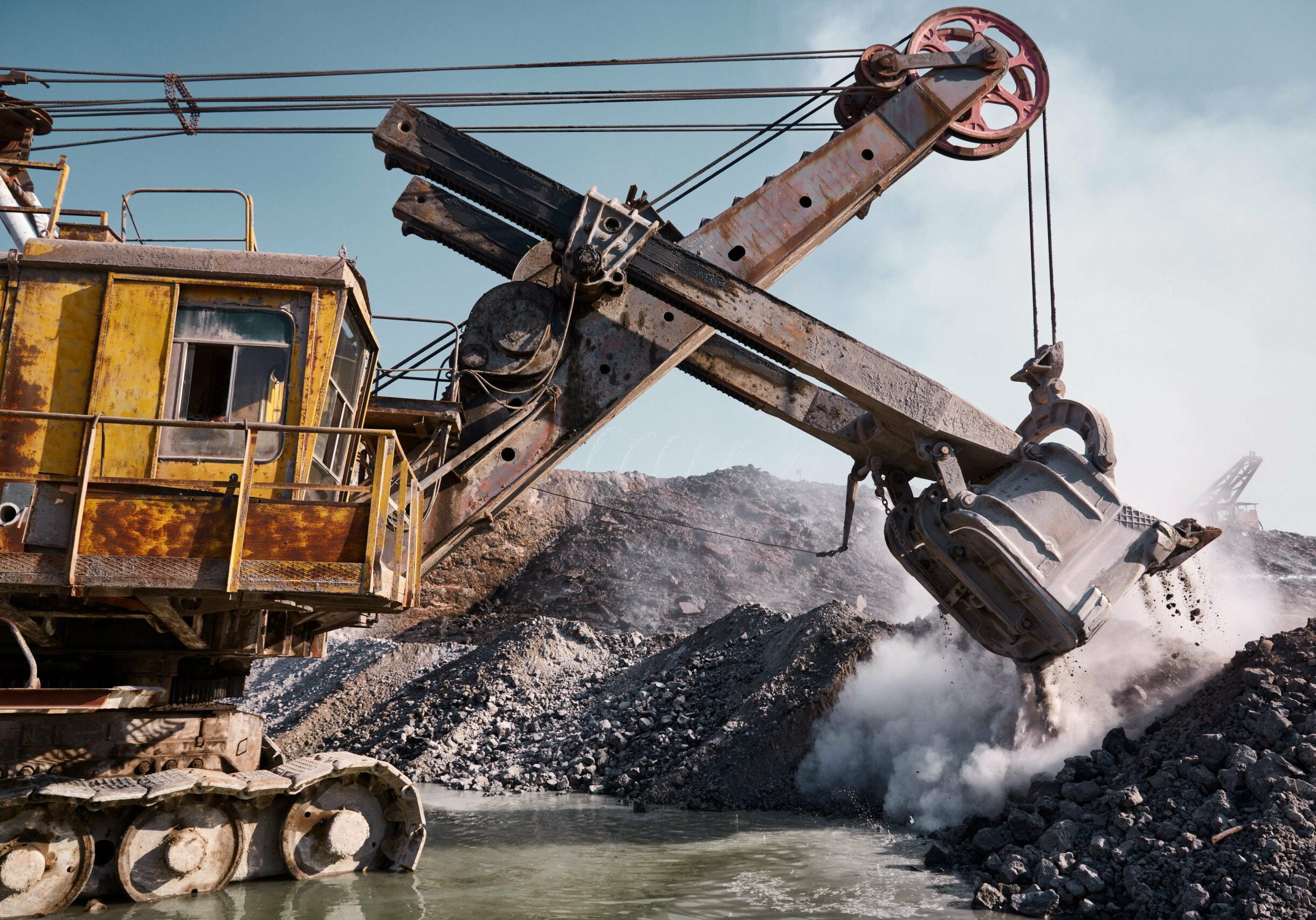 Quarry bucket excavator works in a slag dump Huge quarry bucket excavator works in a hot outdoors slag dump. Heavy industrial metallurgical foggy landscape